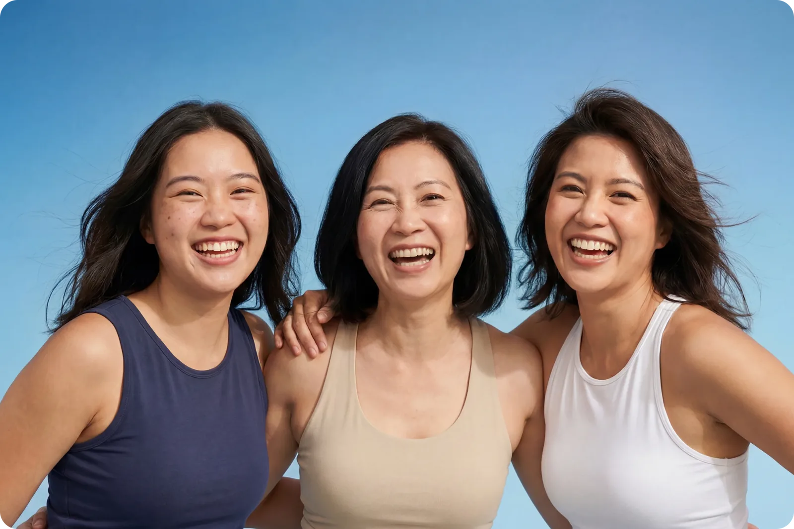 Three women laughing together outdoors